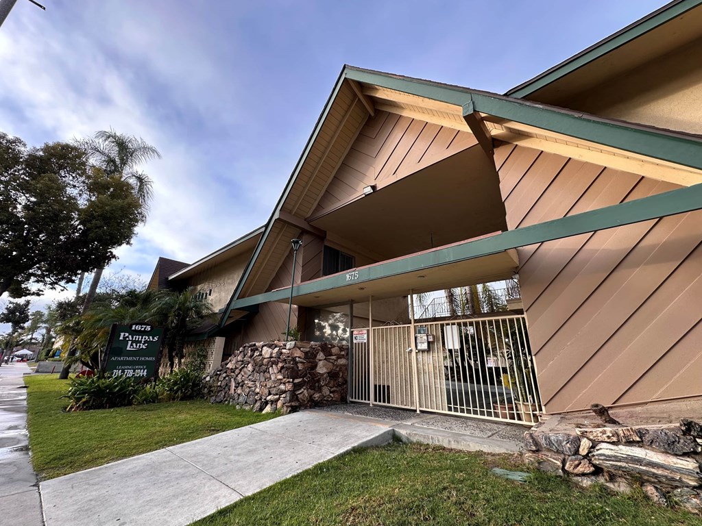 A building with a sign that says "Pine Ridge Apartments" in front of it.
