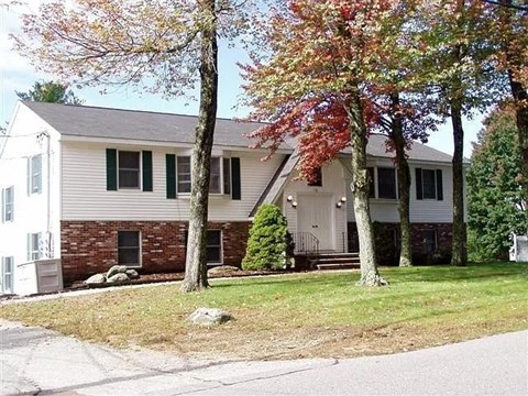A house with a white and grey exterior and a green lawn.