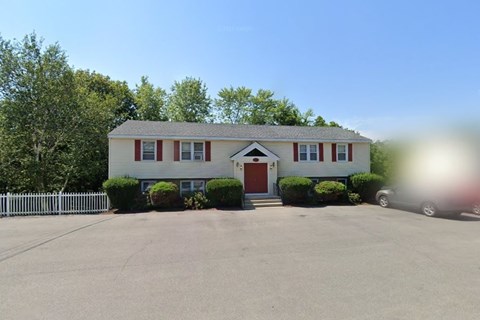 A house with a red door and a white fence.