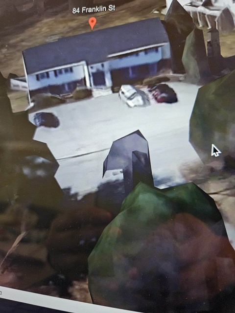 A car is parked in front of a building on 84 Franklin St.