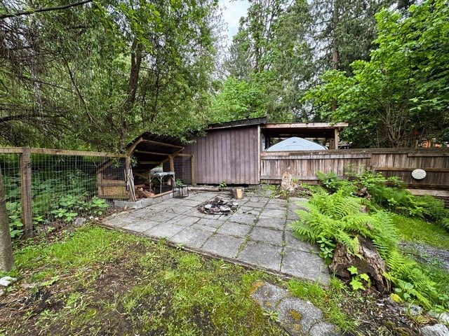 A backyard with a patio and a small building.