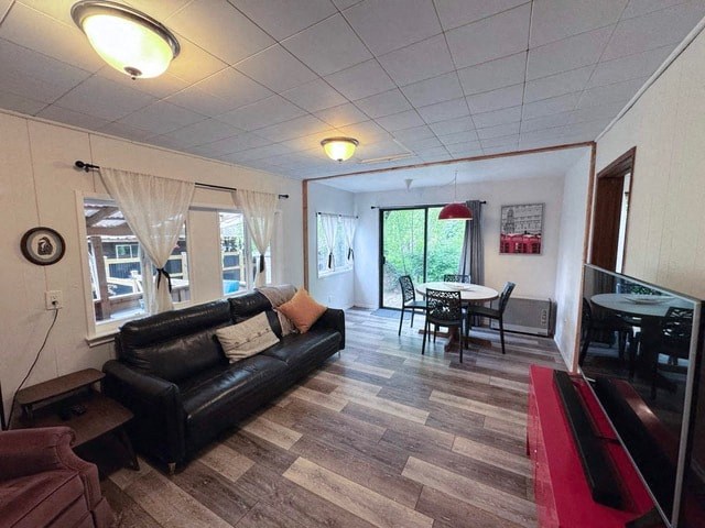 A living room with a black couch and a wooden floor.