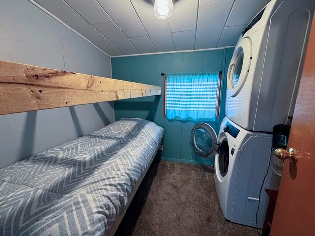 A small room with a bed, a washing machine, and a window.
