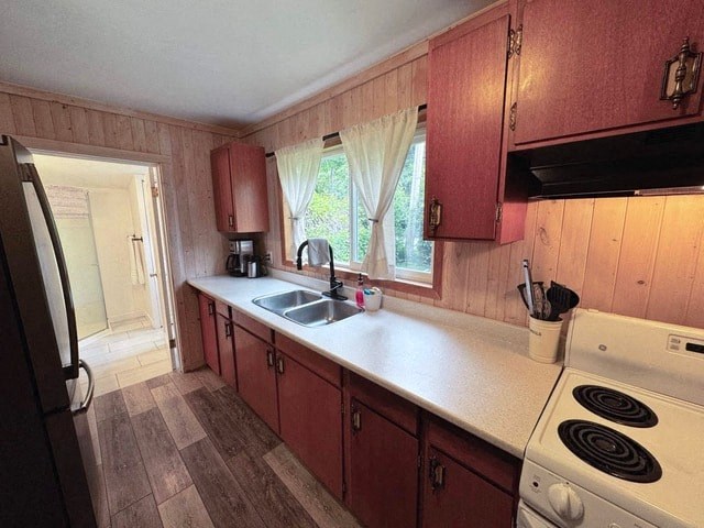 A kitchen with wooden walls and a white stove.