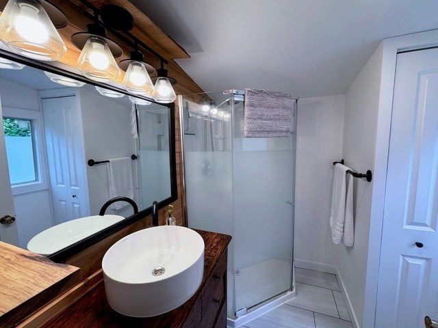 A white sink is on a wooden countertop under a mirror.