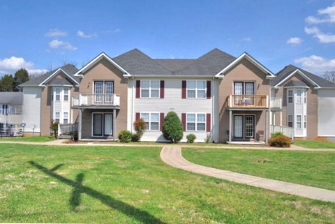 A row of houses with a green lawn in front.