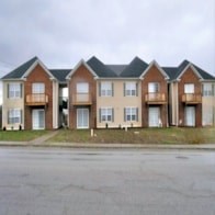 A row of houses with a grassy area in front.