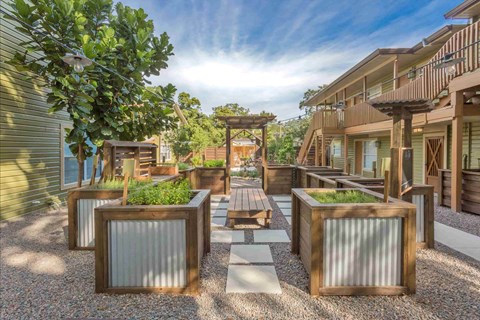 A sunny day in a courtyard with a wooden bench and a table.