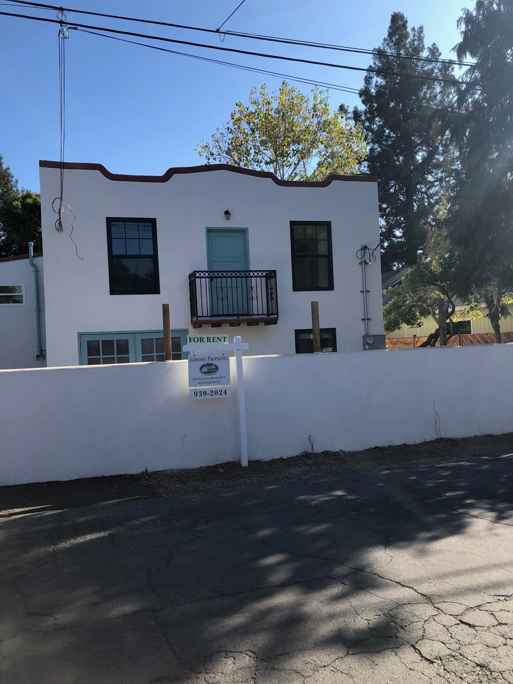 A white house with a sign in front of it.