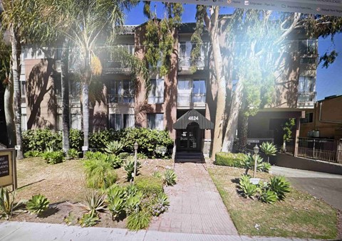 A building with the number 4624 on it is surrounded by trees and plants.
