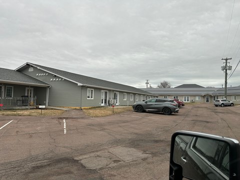 A parking lot with cars and a building in the background.