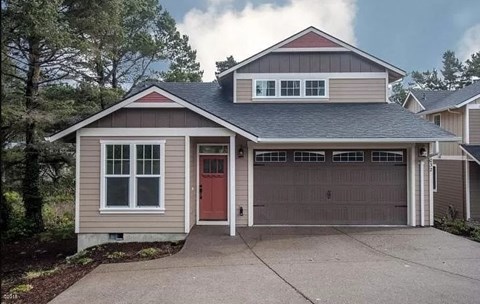 A two-story house with a red door and a garage.