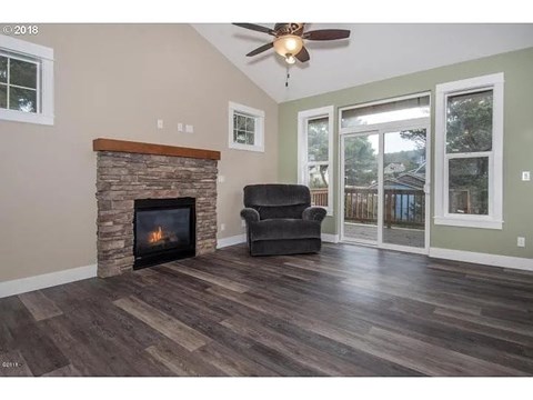 A living room with a fireplace and a ceiling fan.