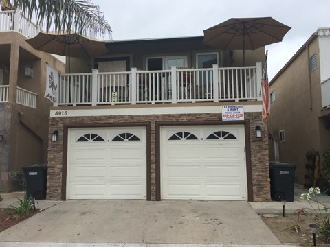 A two-car garage is in front of a house.