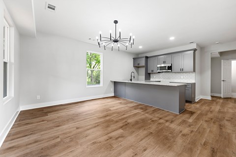 A spacious kitchen with wooden floors and a large island.