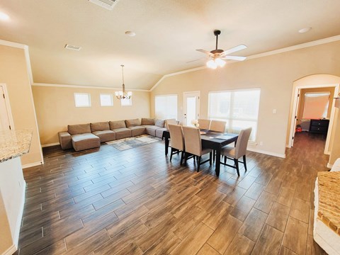 A spacious living room with a dining table and chairs.