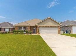 A house with a brown roof and a driveway in front.