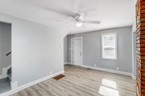 A room with a ceiling fan and a window.