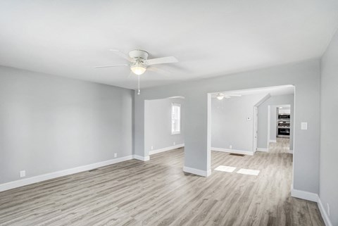 A spacious room with a ceiling fan and light fixture.