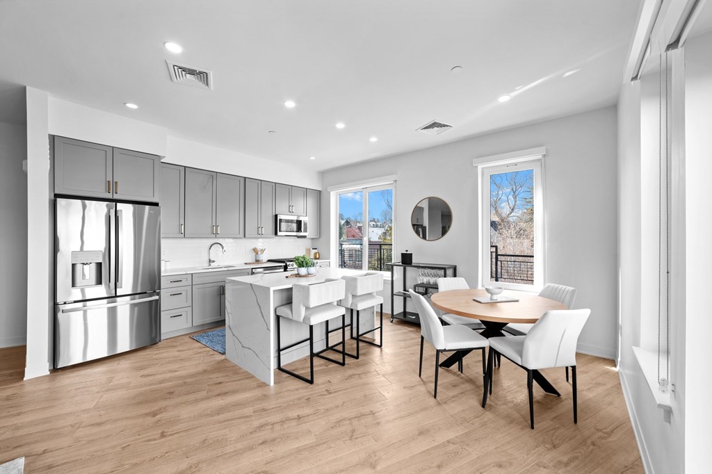 A modern kitchen with a dining table and chairs.
