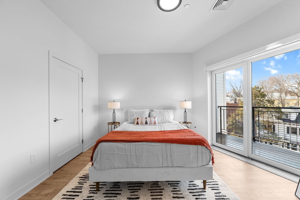 A bedroom with a large bed and a view of the outside.