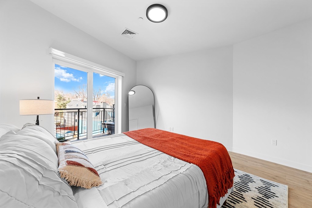 A bedroom with a large bed and a view of the outside.