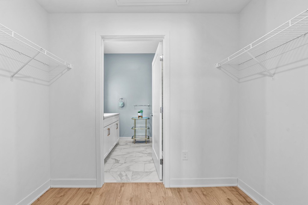 A white room with a doorway leading to a bathroom.
