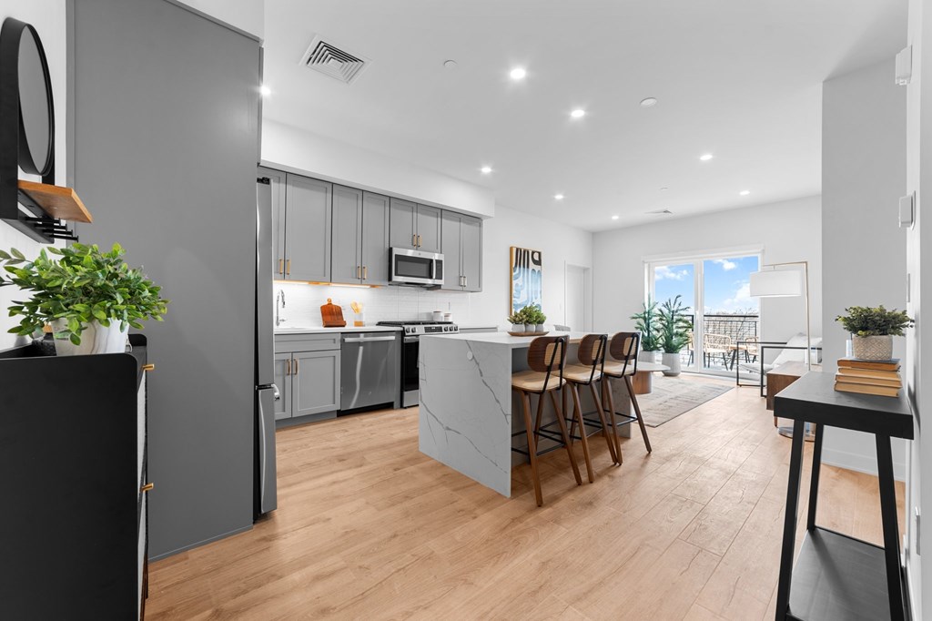 A modern kitchen with wooden floors and a large island.