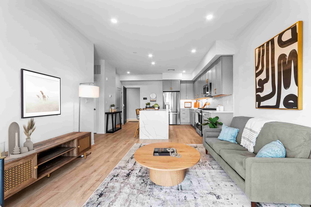 A modern living room with a grey couch and a wooden coffee table.