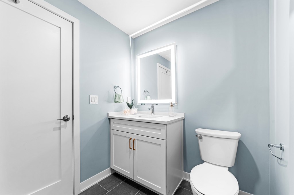 A white toilet sits next to a sink in a bathroom.