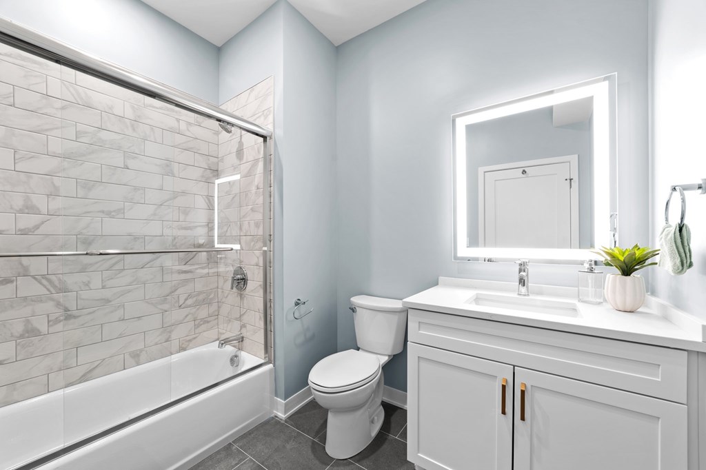 A white toilet sits next to a white sink in a bathroom.