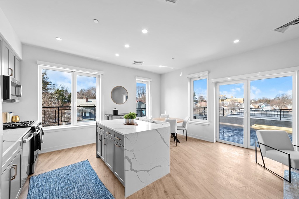 A modern kitchen with a large island and a view of the city.