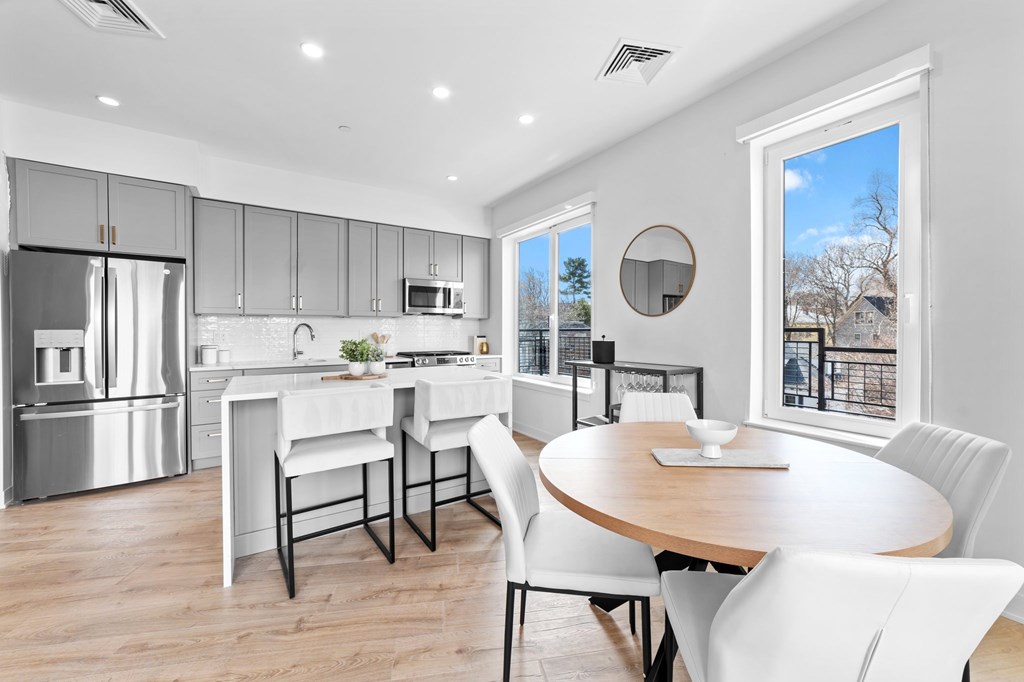 A modern kitchen with a dining table and chairs.