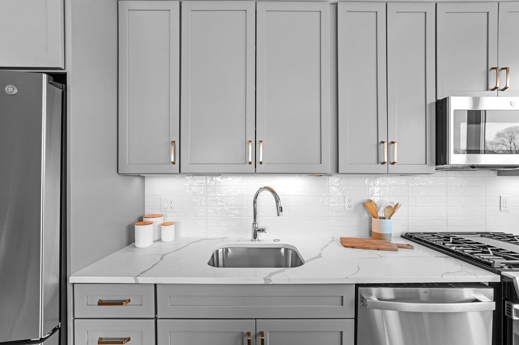 A kitchen with a sink, stove, and refrigerator.