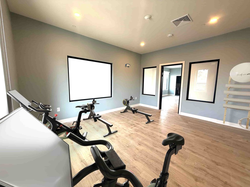 A room with exercise equipment and a whiteboard.