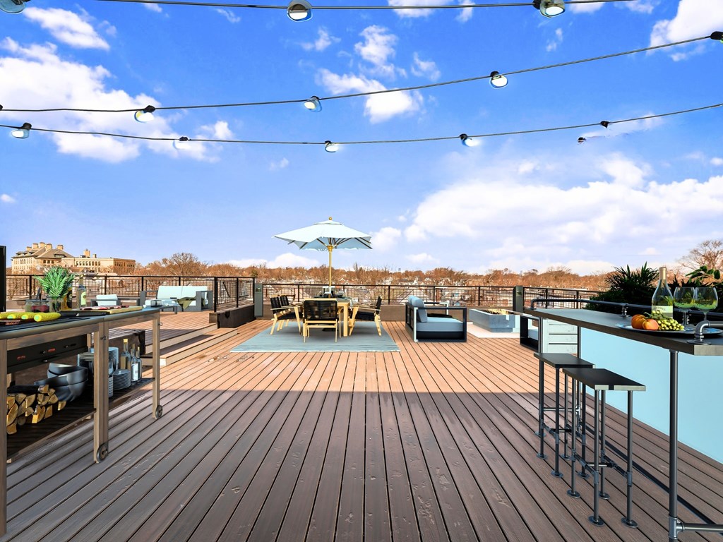 A wooden deck with a table and chairs and a blue umbrella.