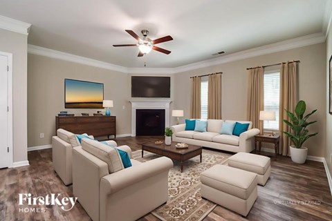 A living room with a fireplace, couches, and a painting on the wall.