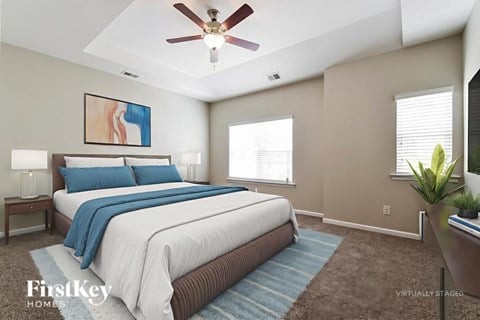 A bedroom with a large bed and a ceiling fan.