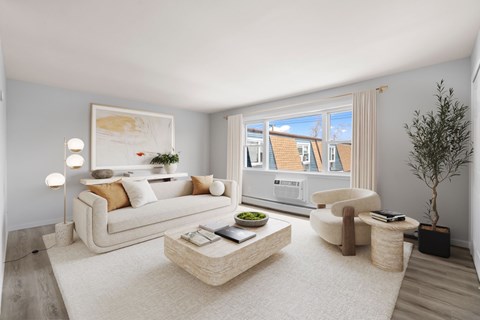A modern living room with a white sofa, a coffee table, and a large window.