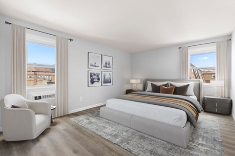 A bedroom with a large bed and a chair.
