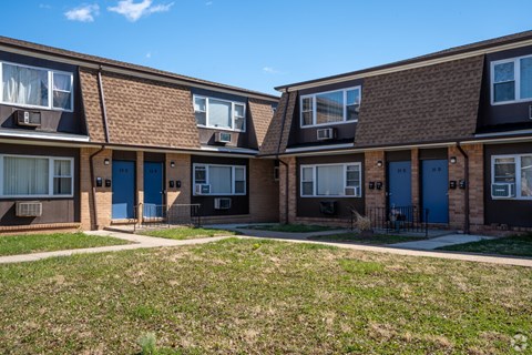 Apartment complex with brown brick buildings and blue doors.