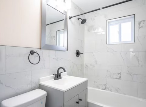 A white sink is on a white countertop in a bathroom.