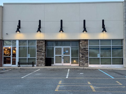 A building with a stone pillar and a glass door.