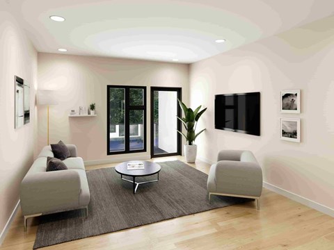 A modern living room with a grey sofa, a coffee table, and a large window.