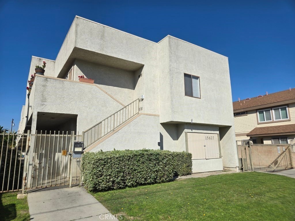 A modern house with a white exterior and a gate in front.
