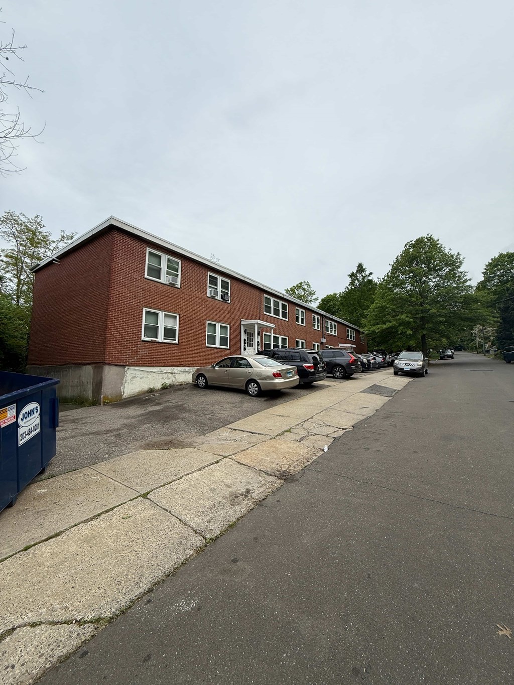 A red brick building with a parking lot in front.