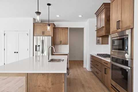 A modern kitchen with wooden cabinets and stainless steel appliances.