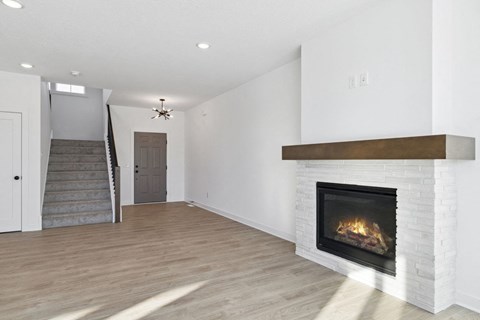 A modern living room with a fireplace and a staircase.