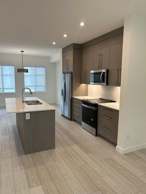 A modern kitchen with wooden cabinets and stainless steel appliances.