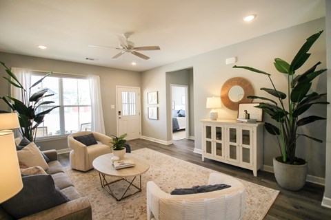 A living room with a white couch, a coffee table, and a ceiling fan.